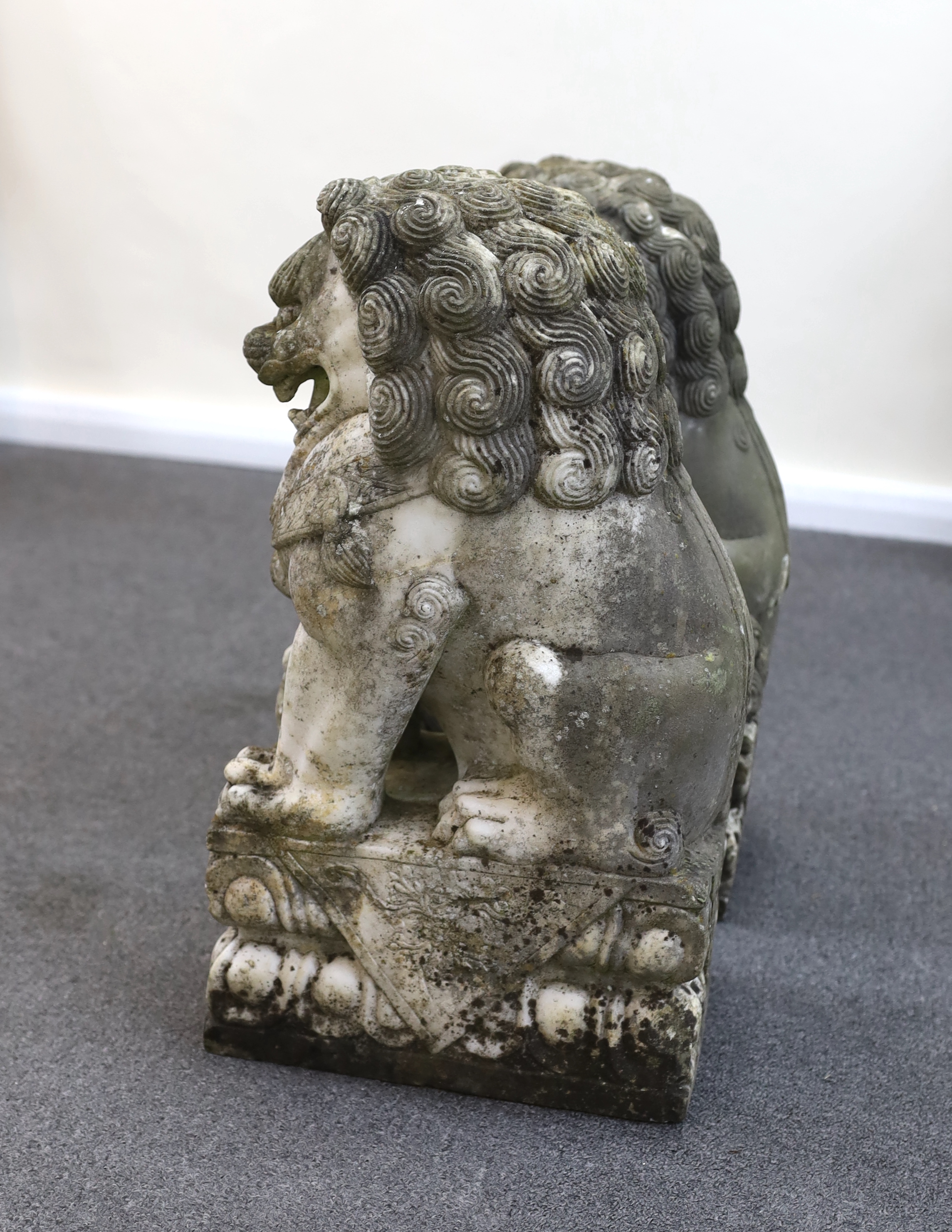 A pair of 20th century Chinese carved marble garden statues modelled as Dogs of Fo, each with weathered finish, 22cm wide, 31cm deep, 54cm high